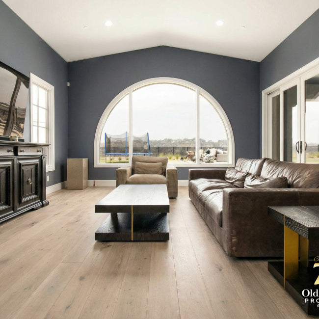 Modern living room with gray walls, wooden floor, and furniture.