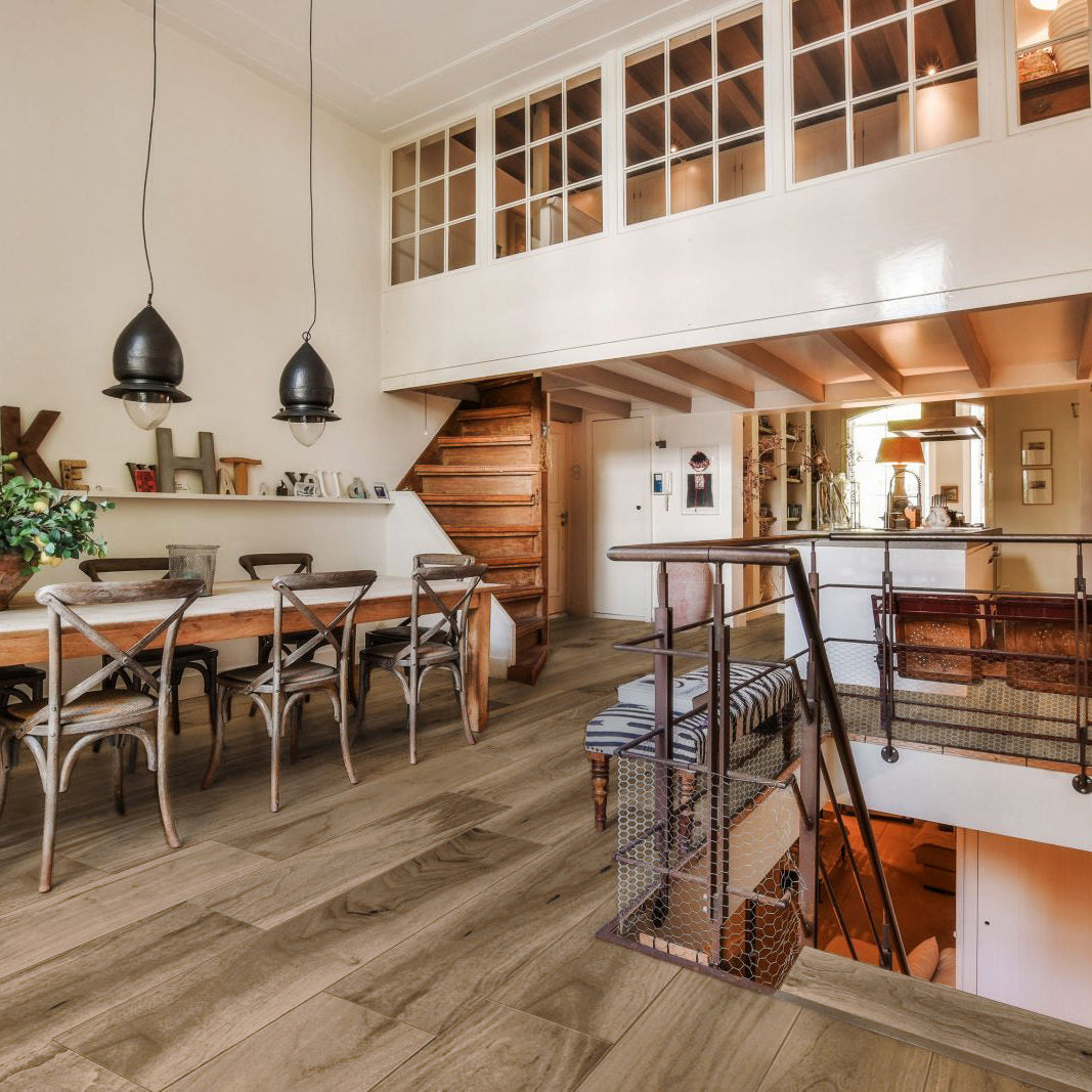 Modern interior with a wooden dining table and chairs, and a staircase leading to an upper level.
