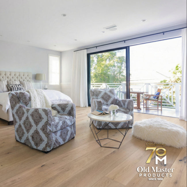 Modern bedroom with a bed, armchair, and large window.