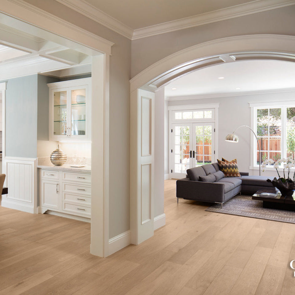 Living room with wooden flooring and a view of the kitchen.